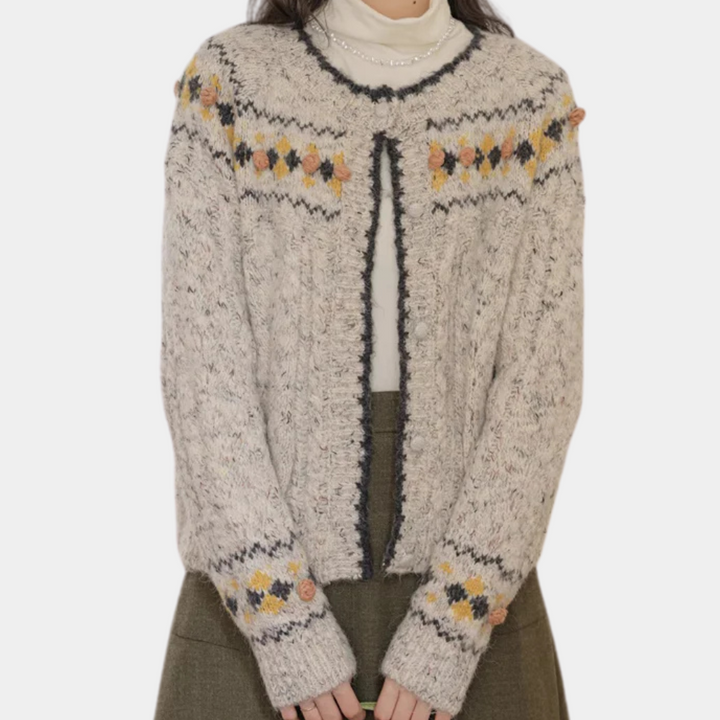 Grijze gebreide damesvest met kleurrijk bloemenpatroon, lange mouwen en ronde hals. Perfect voor herfstmode en casual outfits.