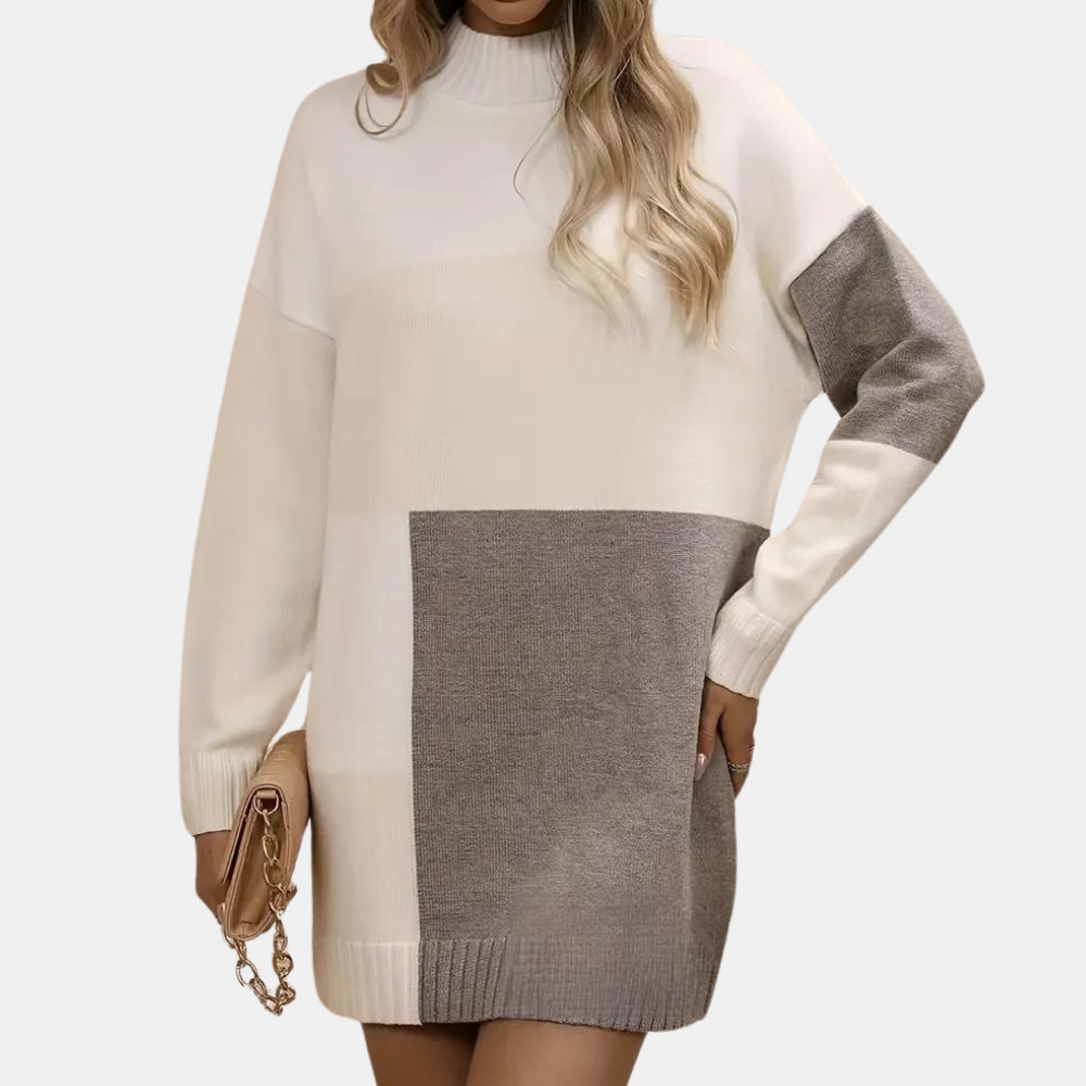 Vrouw in oversized gebreide trui met kleurvlakken, beige en grijs, lange mouwen, modieuze herfstkleding, handtas met ketting.