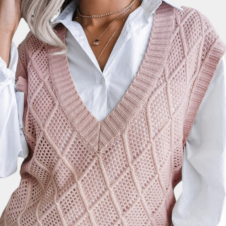 Vrouw draagt roze gebreide spencer over witte blouse, modieuze dameskleding, herfstmode, stijlvolle outfit, trendy gebreid vest, casual chic look.