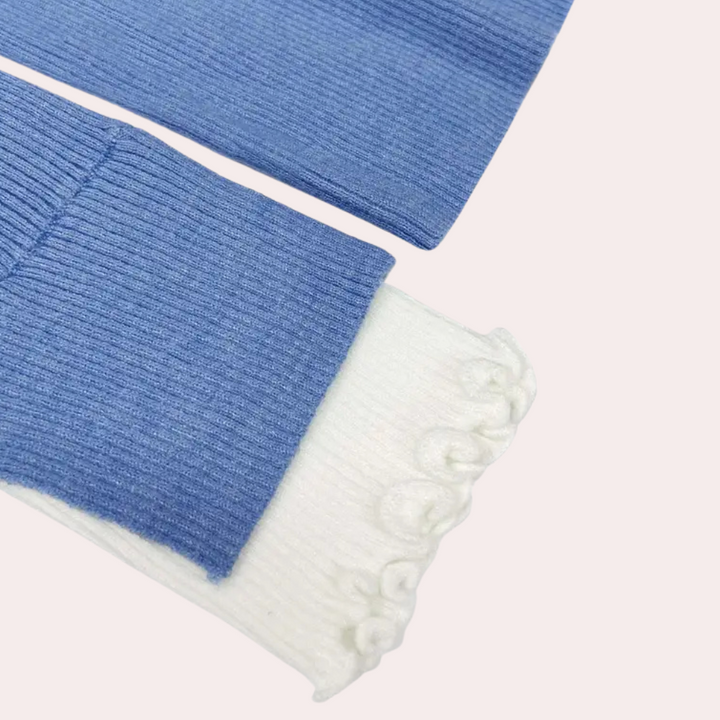 Blauwe en witte gebreide mouw met geribbelde textuur, detail van een trui. Modieuze winterkleding, comfortabele en warme stof.