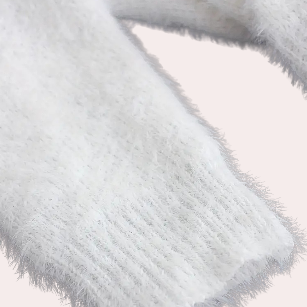 Witte pluizige trui mouw, zachte textuur, close-up. Perfect voor wintermode, warme kleding, comfortabele stijl. Geschikt voor koude dagen.