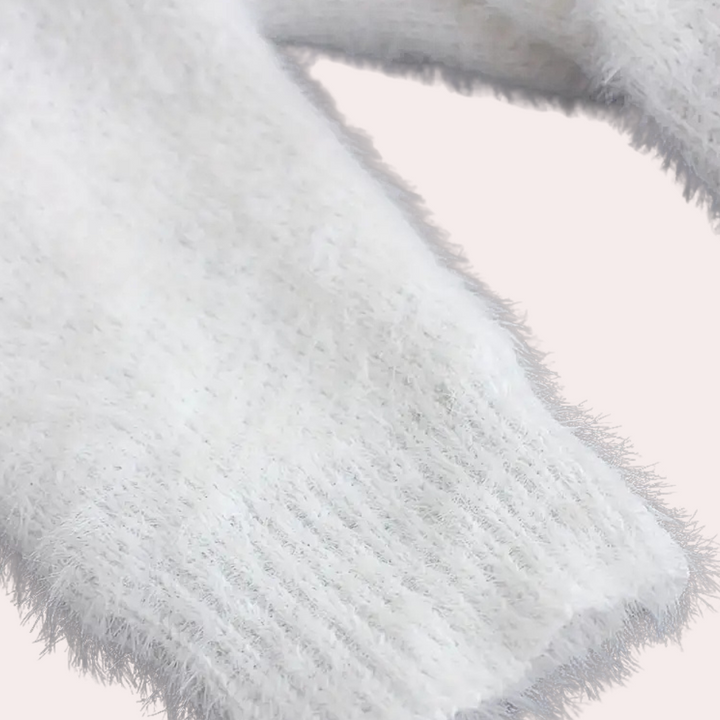 Witte pluizige trui mouw, zachte textuur, close-up. Perfect voor wintermode, warme kleding, comfortabele stijl. Geschikt voor koude dagen.
