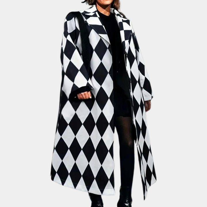 Zwart-witte ruitjesjas, lange damesjas, modieuze harlekijnprint, trendy winterkleding, stijlvolle damesmode, opvallende buitenkleding.