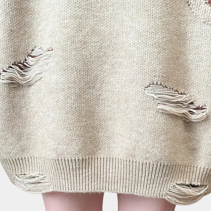 Beige gebreide trui met distressed details, modieuze gaten en gerafelde randen, trendy oversized stijl, perfect voor casual herfst- en winteroutfits.