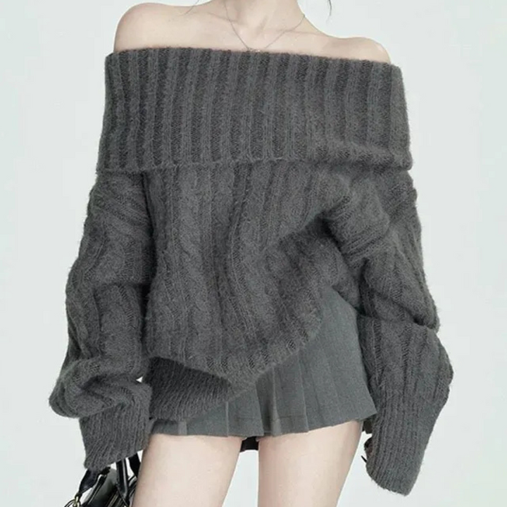 Grijze off-shoulder trui, gebreid met kabelpatroon, gedragen door model. Modieuze dameskleding, herfst-winter stijl, trendy en comfortabel.