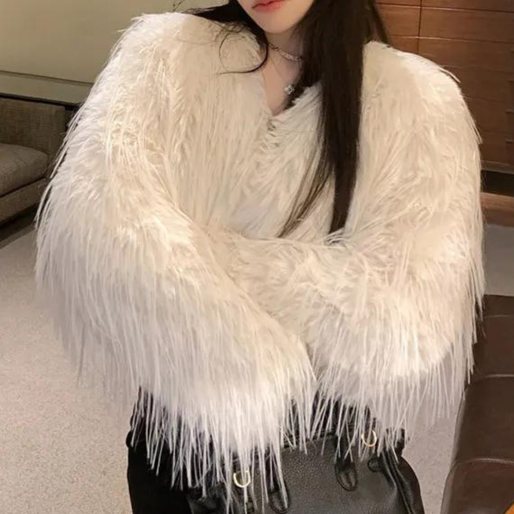 Vrouw in witte, pluizige faux fur jas, modetrend winter 2023, stijlvolle dameskleding, luxe uitstraling, warme winterjas, modeaccessoire.