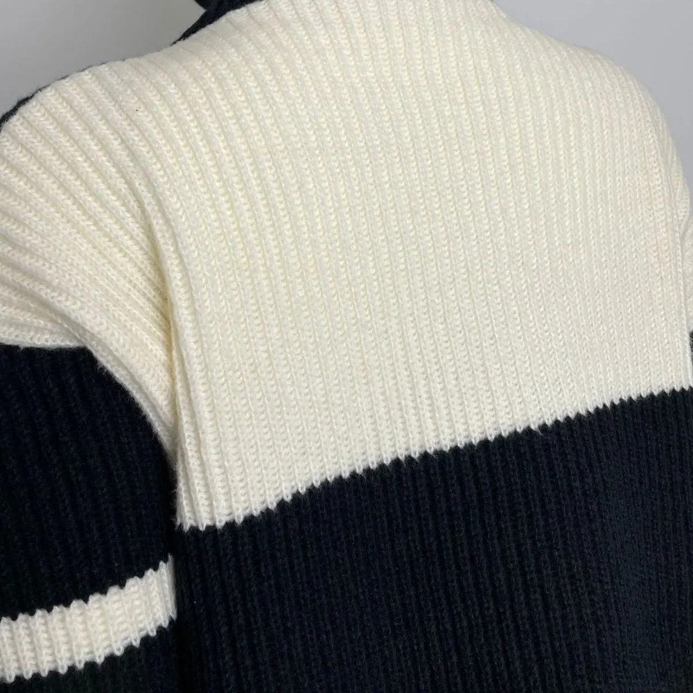 Zwart-witte gebreide trui met horizontale strepen, ribbelpatroon en hoge kraag. Modieuze herentrui, winterkleding, warme gebreide stof.