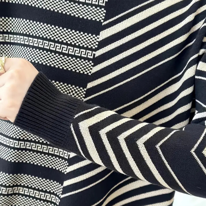 Zwart-witte trui met geometrisch patroon, waaronder zigzag en Griekse sleutelmotieven. Moderne damesmode, stijlvolle winterkleding.