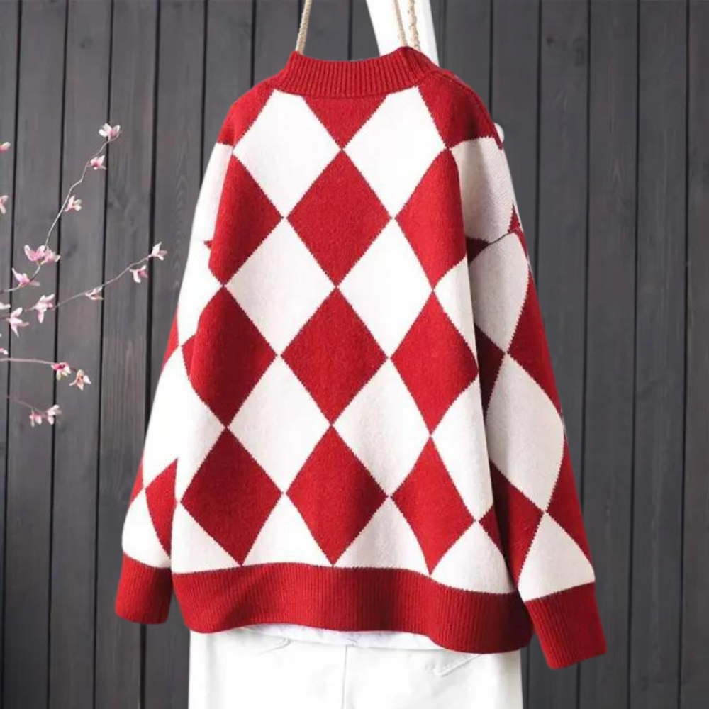 Rode en witte ruitjestrui op een hanger tegen een donkere houten achtergrond, modieuze herfstsweater, gebreide kleding, trendy damesmode.