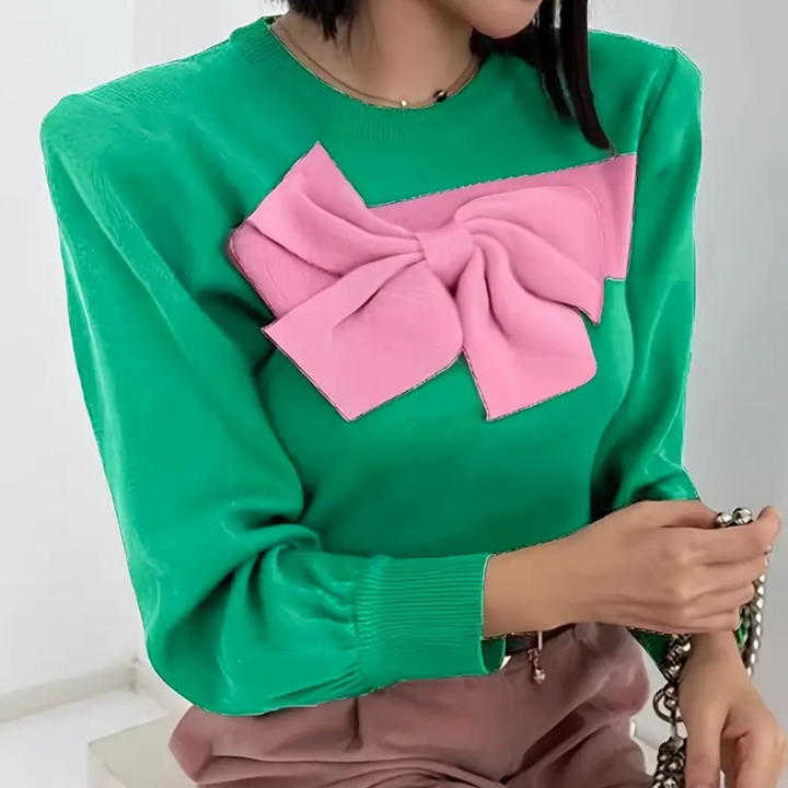 Groene trui met opvallende roze strik, damesmode, trendy kleding, stijlvolle outfit, modieuze dameskleding, casual chic look.