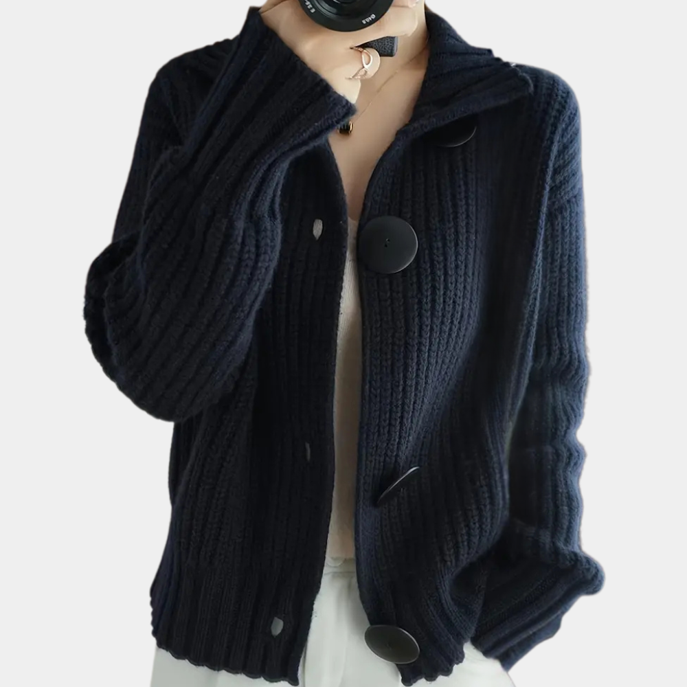 Donkerblauw gebreid damesvest met grote knopen, lange mouwen en geribbelde textuur. Stijlvol en warm, perfect voor herfst- en wintermode.
