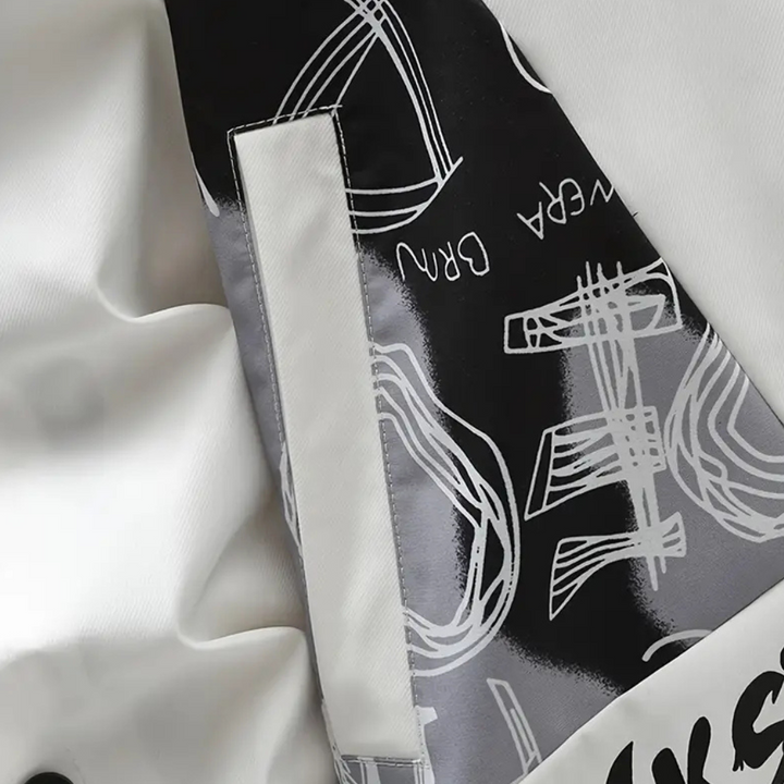 Wit en zwart abstract ontwerp op stof met grafische patronen en tekst, close-up van moderne modeprint, trendy kledingstof, artistieke textielstijl.