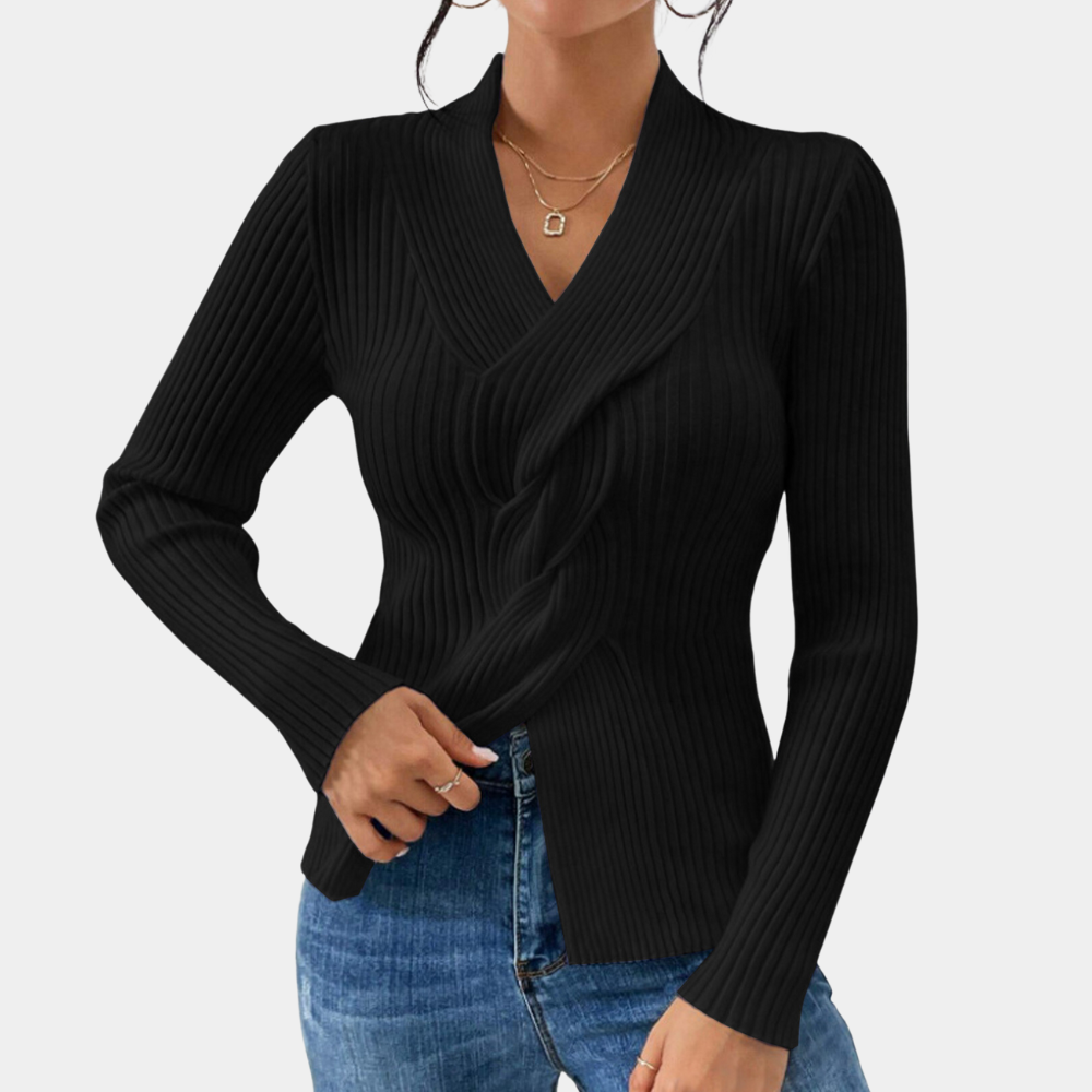 Zwarte geribbelde damestrui met lange mouwen, V-hals en gedraaid detail, gecombineerd met blauwe jeans. Stijlvolle herfstmode voor vrouwen.