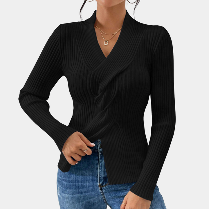 Zwarte geribbelde damestrui met lange mouwen, V-hals en gedraaid detail, gecombineerd met blauwe jeans. Stijlvolle herfstmode voor vrouwen.