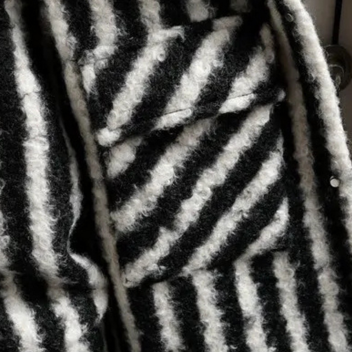 Zwart-wit gestreepte wollen stof met textuur, close-up. Geschikt voor modeontwerp, winterkleding, hoogwaardige textielmaterialen.
