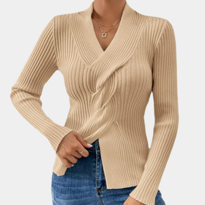 Beige geribbelde trui met V-hals en lange mouwen, gedragen door een model. Modieuze dameskleding, perfect voor casual en chique outfits.