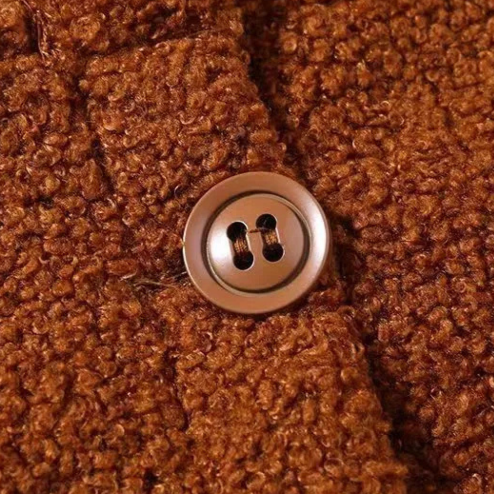 Bruine wollen jas met knoop, close-up. Textuur van warme, gebreide stof. Perfect voor herfst- en wintermode. Comfortabele en stijlvolle kleding.