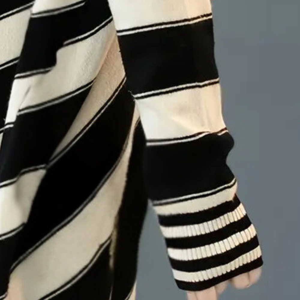 Zwart-wit gestreepte trui met lange mouwen, close-up. Modieuze dameskleding, herfst-winter collectie, comfortabele en stijlvolle outfit.