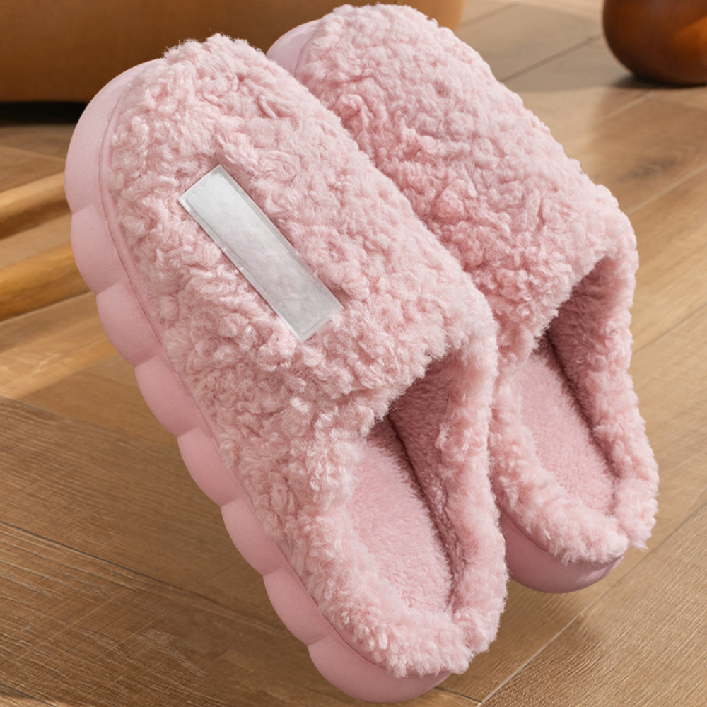 Roze pluche pantoffels met dikke zool op houten vloer, comfortabele dames slippers, warme winter sloffen, trendy huis schoeisel, gezellig interieur.