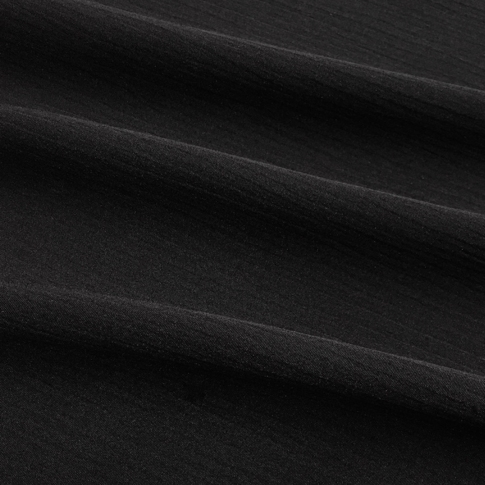 Zwarte katoenen stof close-up, textuur en plooien zichtbaar. Ideaal voor modeontwerp, kledingproductie, hoogwaardige textielmaterialen.