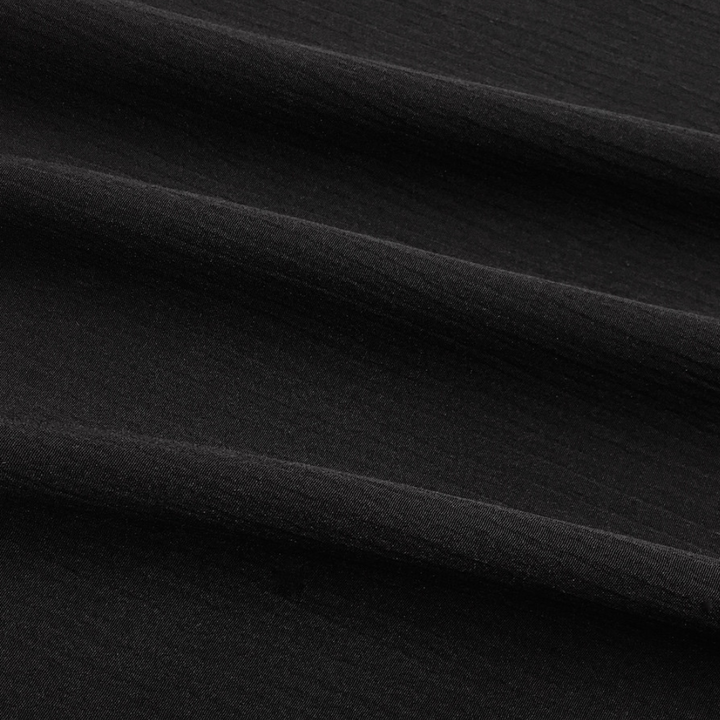 Zwarte katoenen stof close-up, textuur en plooien zichtbaar. Ideaal voor modeontwerp, kledingproductie, hoogwaardige textielmaterialen.