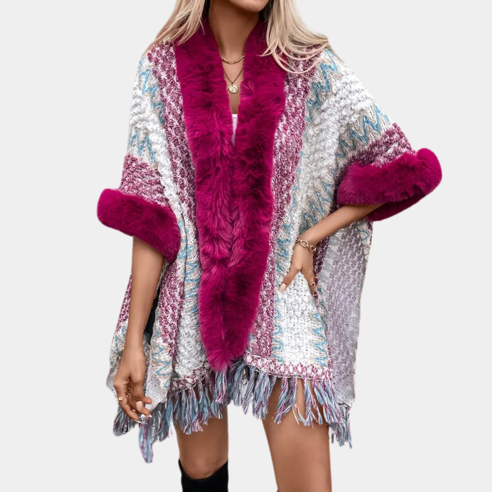 Vrouw draagt kleurrijke poncho met roze bontkraag en franjes, modieuze winterkleding, trendy damesmode, stijlvolle warme outfit.