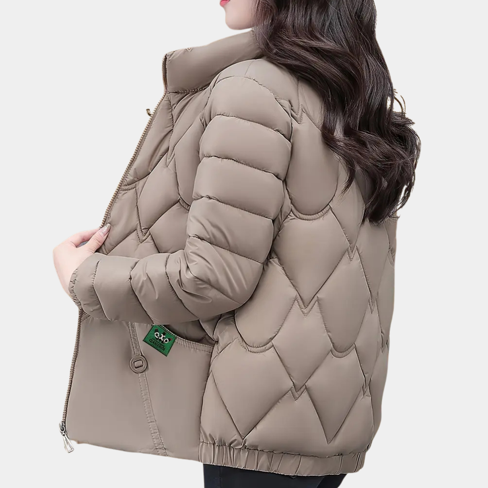 Vrouw in beige gewatteerde jas met ruitpatroon, zijaanzicht. Wintermode, warme damesjas, trendy design, casual kledingstijl.