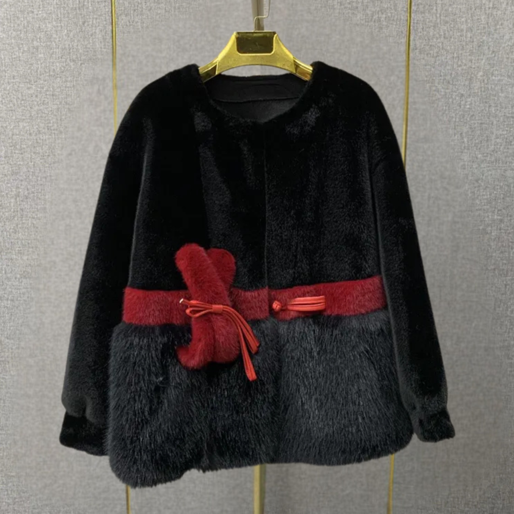 Zwarte faux bontjas met rode riem, elegante wintermode voor dames, warme en stijlvolle jas, perfect voor koude seizoenen, luxe uitstraling.