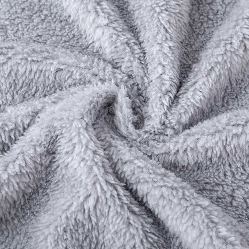 Grijze pluche fleece stof close-up, zachte textuur, ideaal voor warme dekens en kleding. Perfect voor wintermode en huisdecoratie.