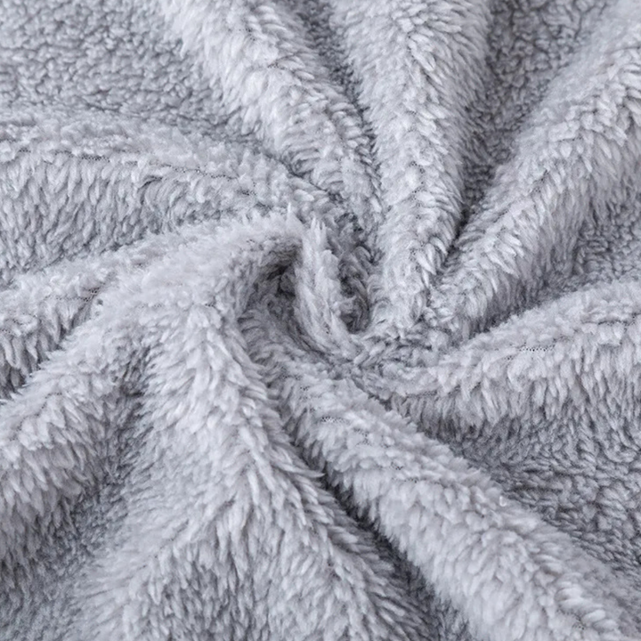 Grijze pluche fleece stof close-up, zachte textuur, ideaal voor warme dekens en kleding. Perfect voor wintermode en huisdecoratie.