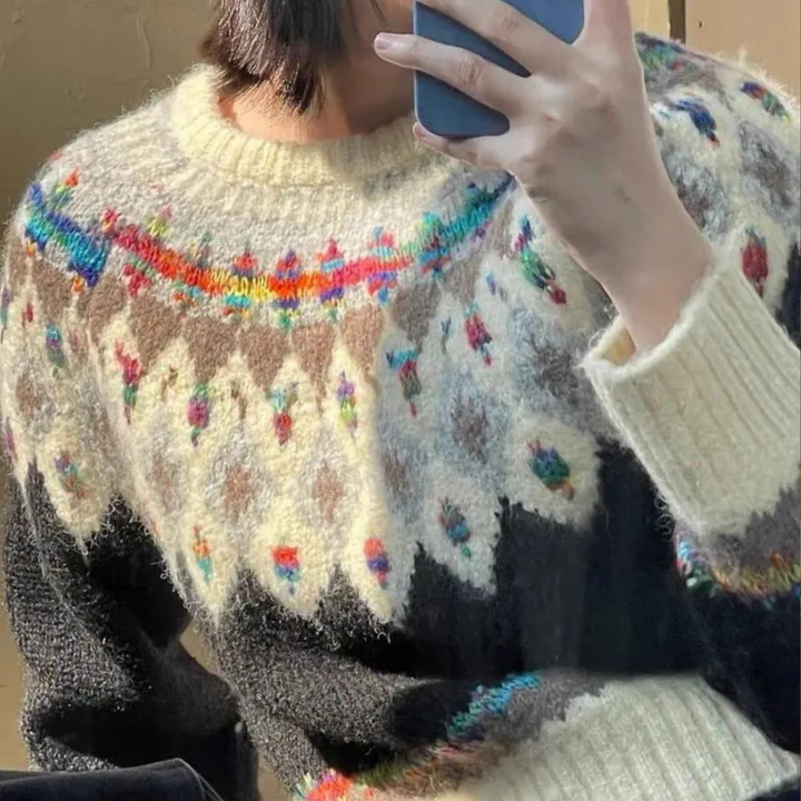 Persoon draagt kleurrijke Noorse trui met geometrisch patroon en maakt selfie met smartphone. Warme wintermode, gebreide kleding, Scandinavisch design.
