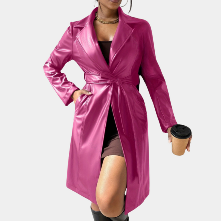 Roze leren trenchcoat voor dames, stijlvolle herfstmode, met ceintuur en lange mouwen, gecombineerd met bruine jurk en zwarte laarzen.