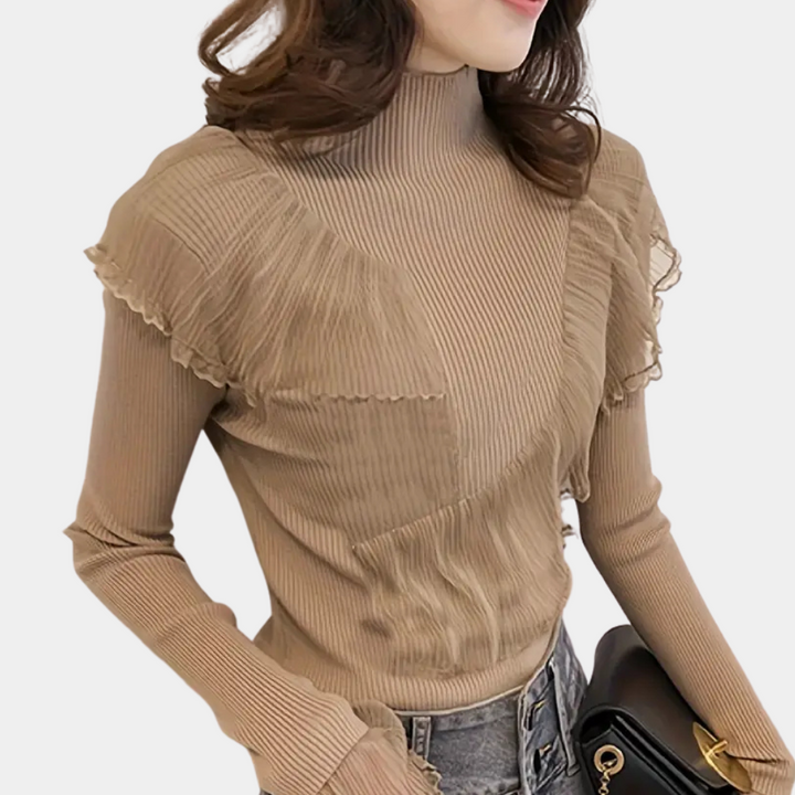 Vrouw in beige geribbelde coltrui met ruches, draagt een zwarte tas. Modieuze dameskleding, herfststijl, casual chic outfit.