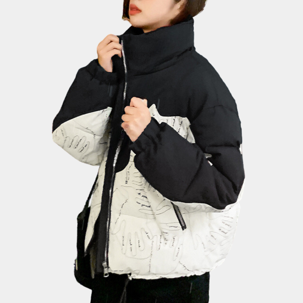 Dames winterjas met zwart-wit handafdrukken, hoge kraag en ritssluiting. Modieuze en warme jas voor koude seizoenen.