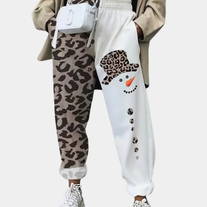 Damesbroek met asymmetrisch ontwerp: linker pijp met luipaardprint, rechter pijp met sneeuwpopmotief. Trendy mode, casual stijl, unieke look.