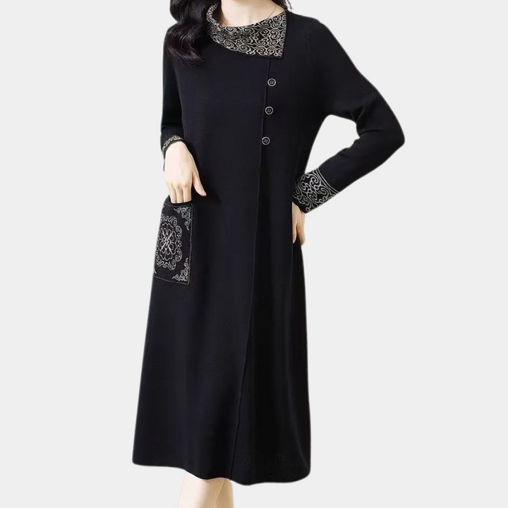 Zwarte damesjurk met lange mouwen, knoopsluiting en kanten details op kraag, mouwen en zak. Elegante en stijlvolle kleding voor elke gelegenheid.