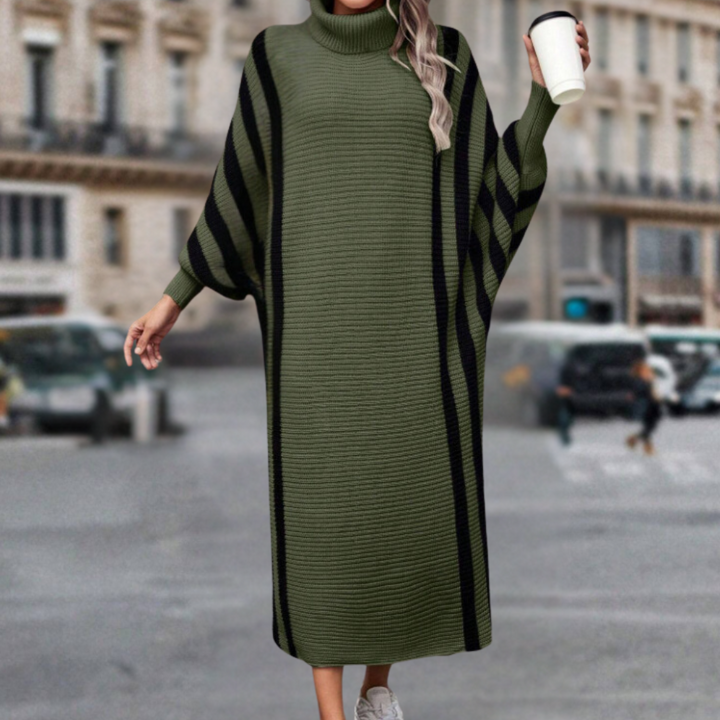 Vrouw in groene oversized trui jurk met zwarte strepen, houdt een koffiebeker vast, stadsachtergrond. Modieuze herfstkleding, casual stijl.