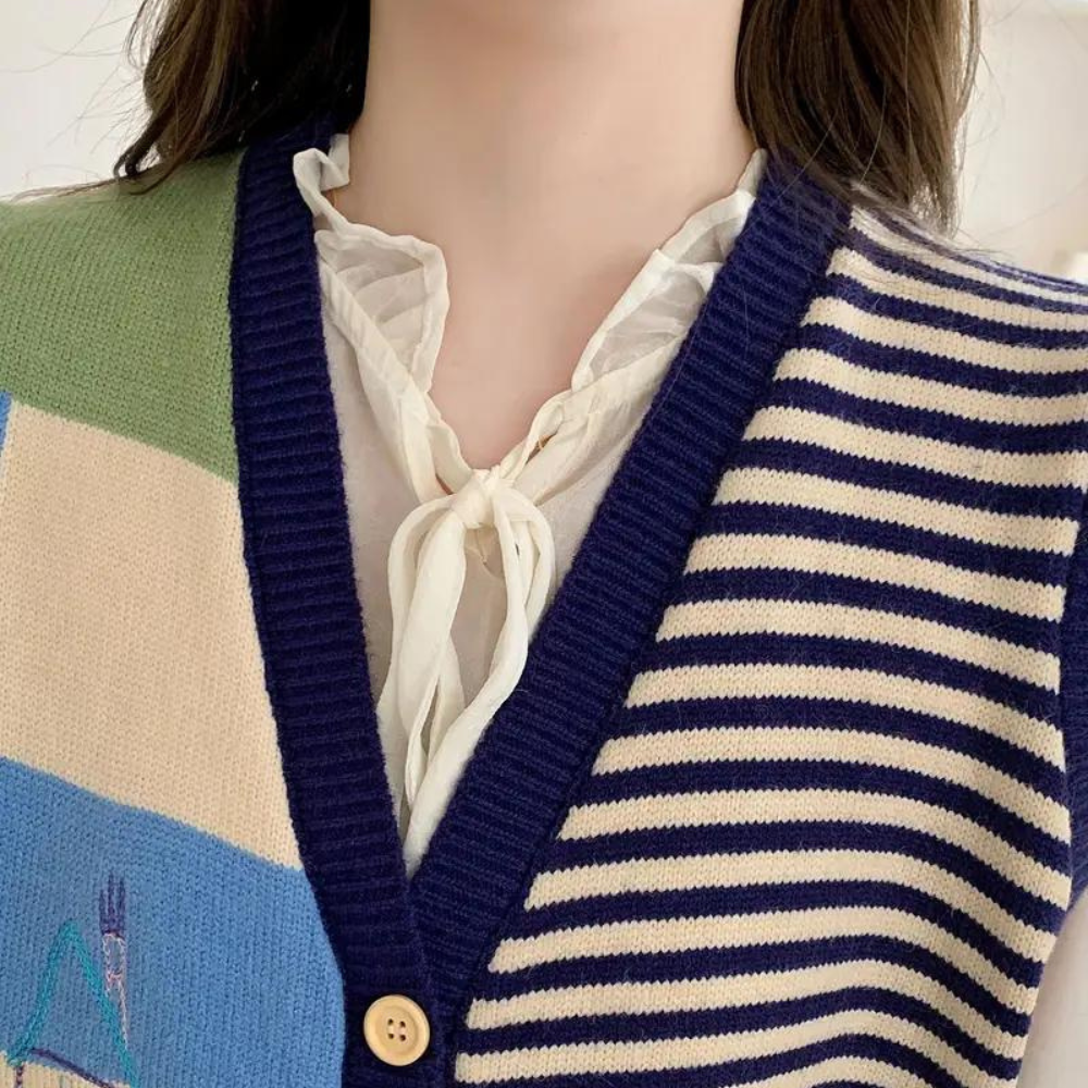 Damestrui met blauw-witte strepen en kleurrijke vlakken, V-hals en knoopsluiting. Modieuze gebreide kleding, casual stijl, herfstmode.