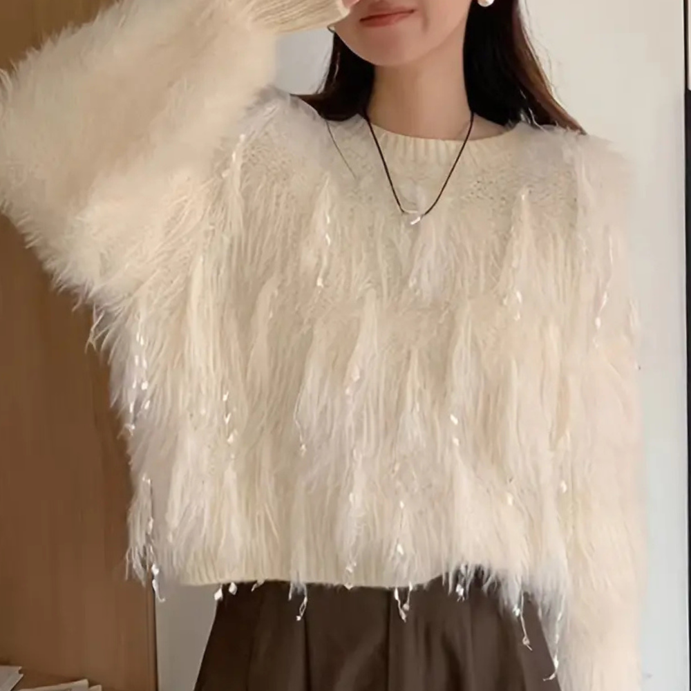 Witte pluizige trui met pailletten, gedragen door vrouw. Modieuze winterkleding, trendy damesmode, warme gebreide trui voor koude seizoenen.