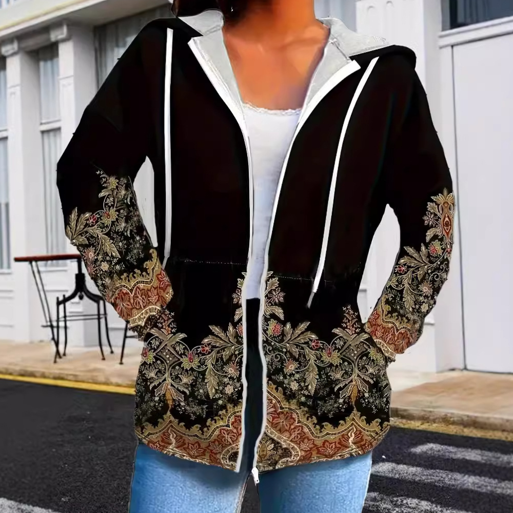 Vrouw draagt stijlvolle zwarte hoodie met kleurrijk paisley-patroon, casual mode, straatstijl, comfortabele kleding, trendy dameskleding.