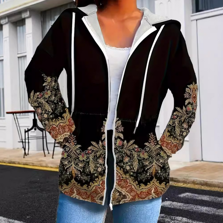 Vrouw draagt stijlvolle zwarte hoodie met kleurrijk paisley-patroon, casual mode, straatstijl, comfortabele kleding, trendy dameskleding.