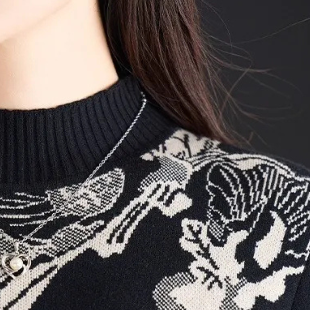 Zwart-witte trui met schedelprint en zilveren ketting, modieuze dameskleding, trendy herfstmode, close-up detail, casual stijl.