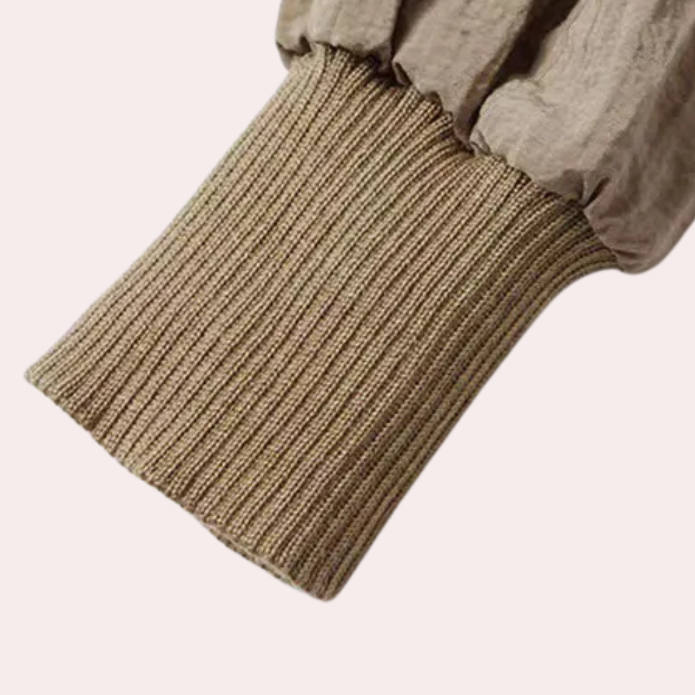 Beige gebreide mouwboord van een jas, close-up. Modieuze, comfortabele stof, ideaal voor herfst- en winterkleding. Stijlvol en veelzijdig ontwerp.
