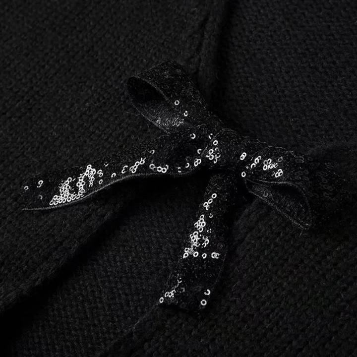 Zwarte gebreide stof met glinsterende zwarte paillettenstrik, elegante modeaccessoire, textuur en detail, stijlvolle kledingdecoratie.