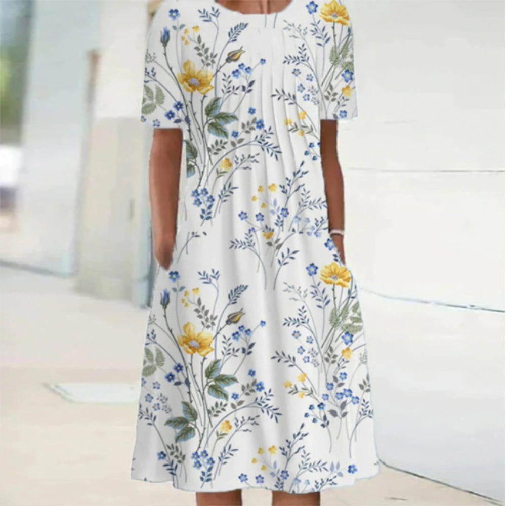 Witte zomerjurk met korte mouwen, bloemenprint in geel en blauw, casual en elegant, perfect voor warme dagen. Comfortabele pasvorm, modieuze stijl.