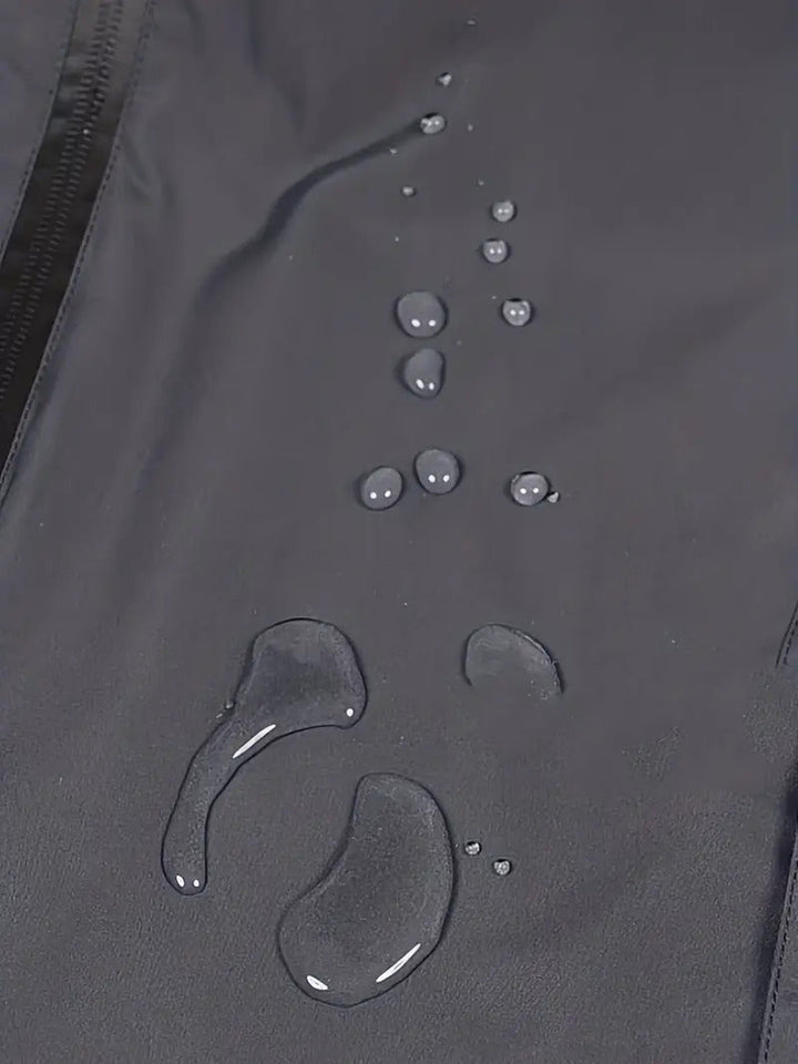 Waterdruppels op waterdichte zwarte stof, close-up. Ideaal voor regenjassen, outdoor kleding. Hoogwaardige, duurzame waterafstotende materialen.