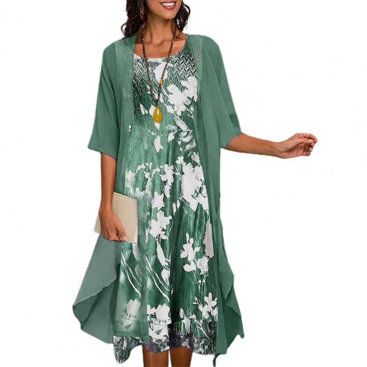 Groene zomerjurk met bloemenprint, driekwart mouwen en luchtige stof. Perfect voor casual en elegante zomerse looks.