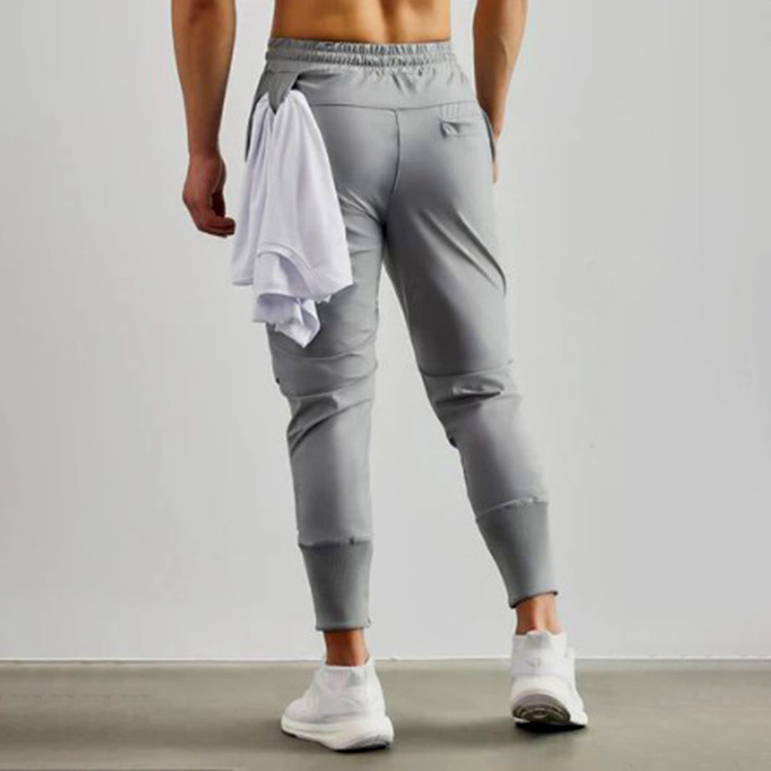 Grijze heren joggingbroek, sportief design, elastische tailleband, comfortabele pasvorm, ideaal voor fitness en casual wear.