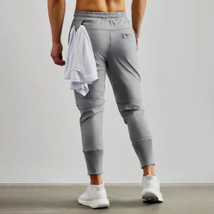 Grijze heren joggingbroek, sportief design, elastische tailleband, comfortabele pasvorm, ideaal voor fitness en casual wear.