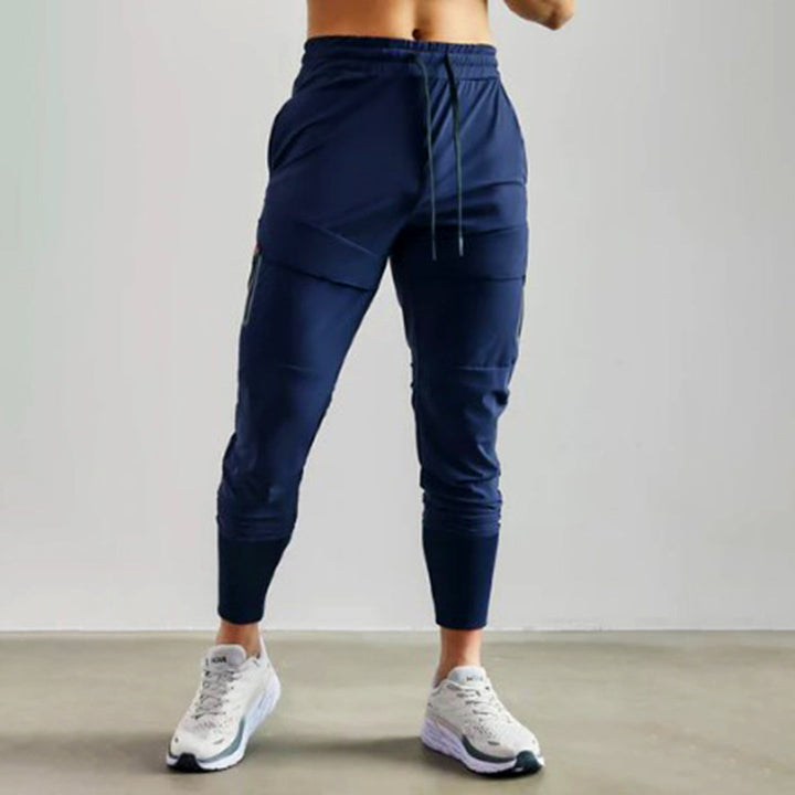 Donkerblauwe heren joggingbroek, sportief design, elastische tailleband, geschikt voor fitness en casual wear, comfortabele pasvorm.